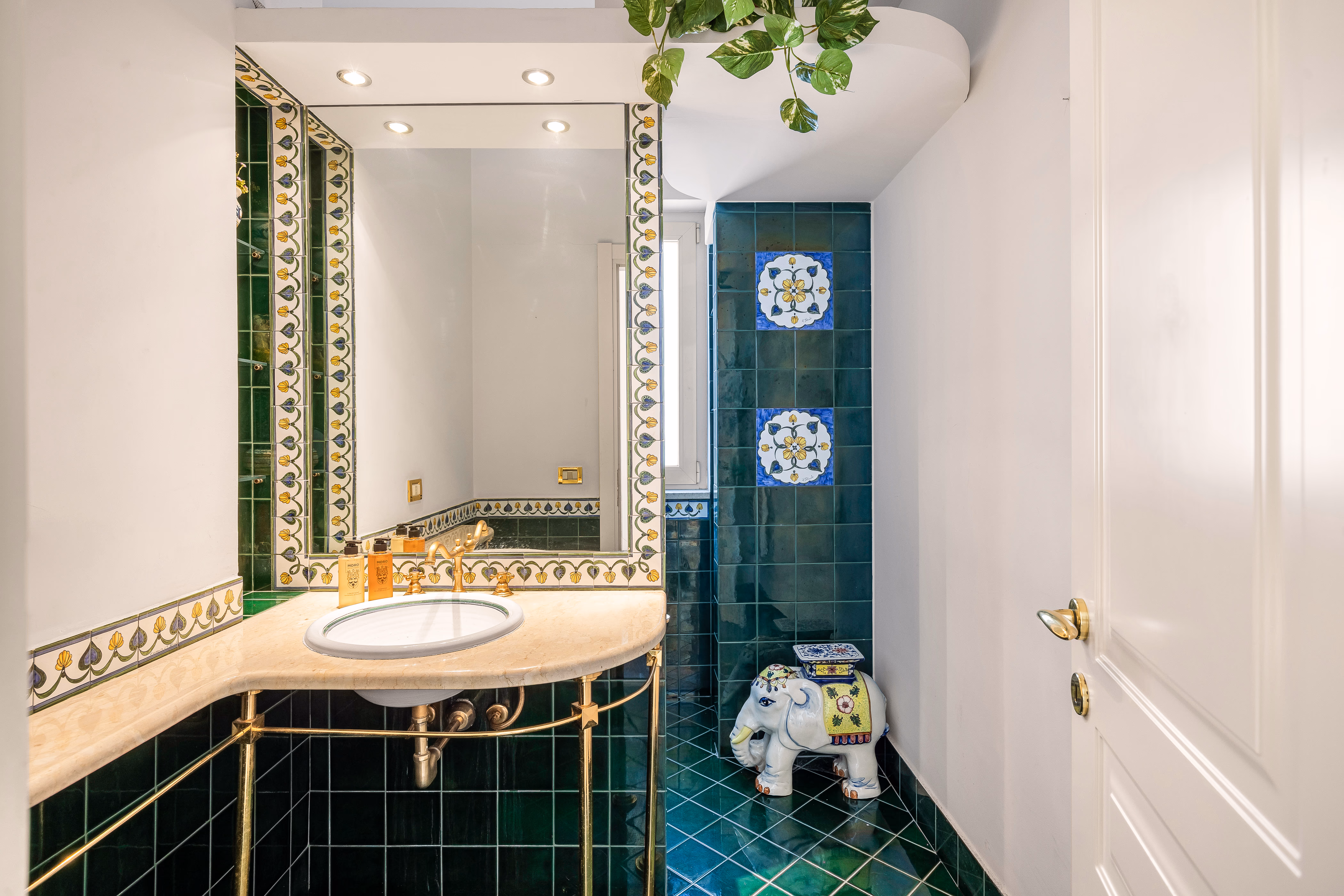 Bathroom with arched shower alcove and warm tiles
