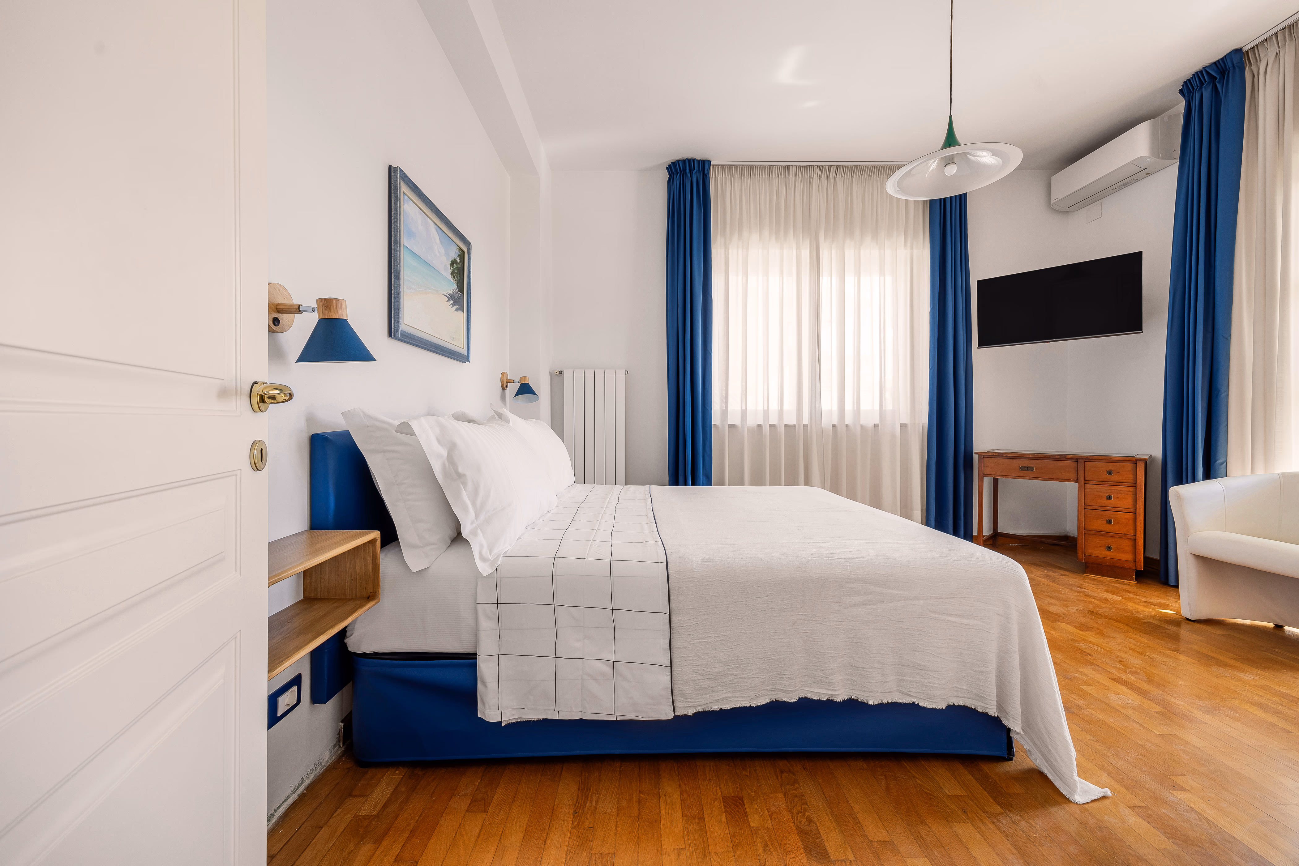 Queen bedroom with warm light and wooden furniture