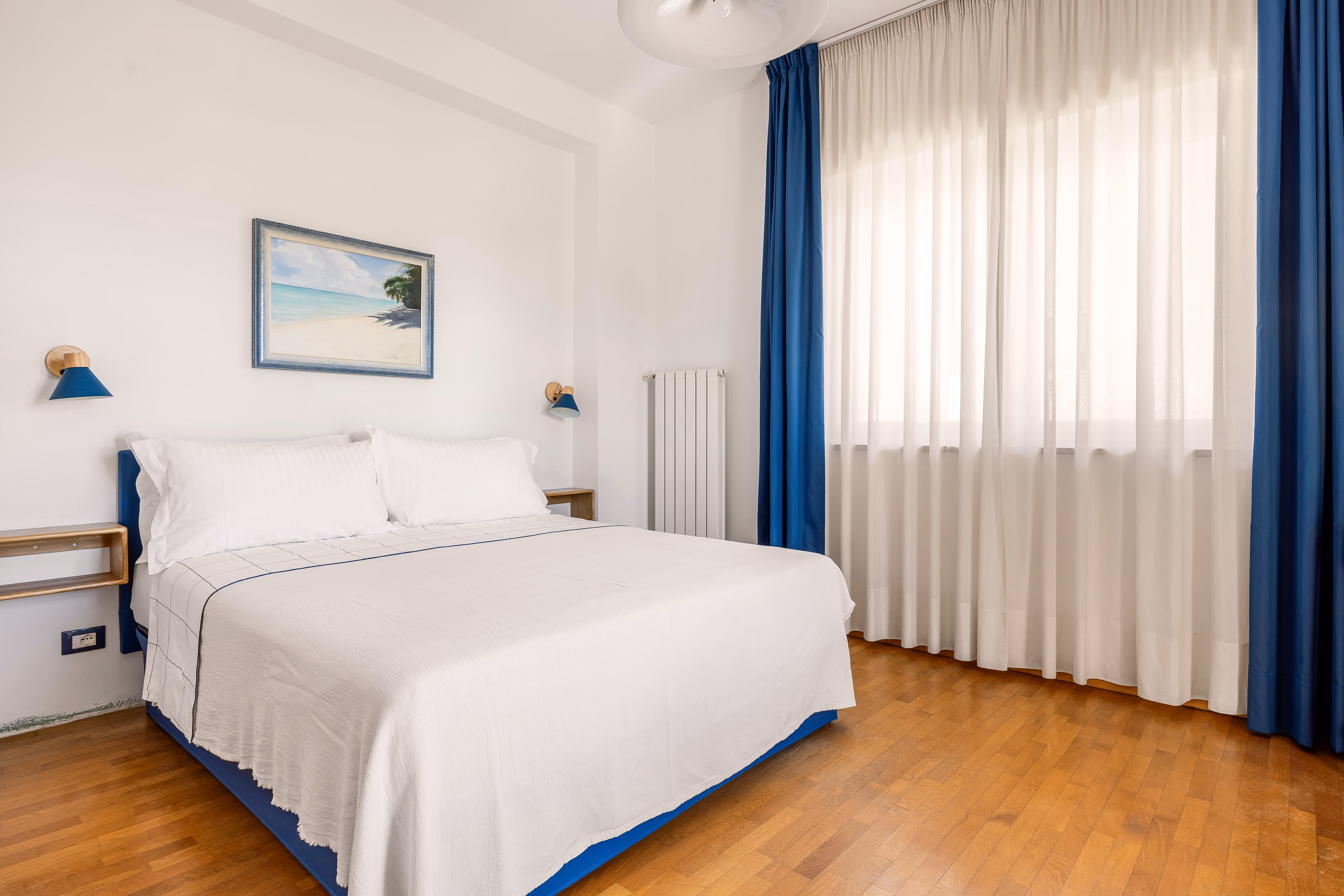 Queen bedroom with blue curtains and balcony door