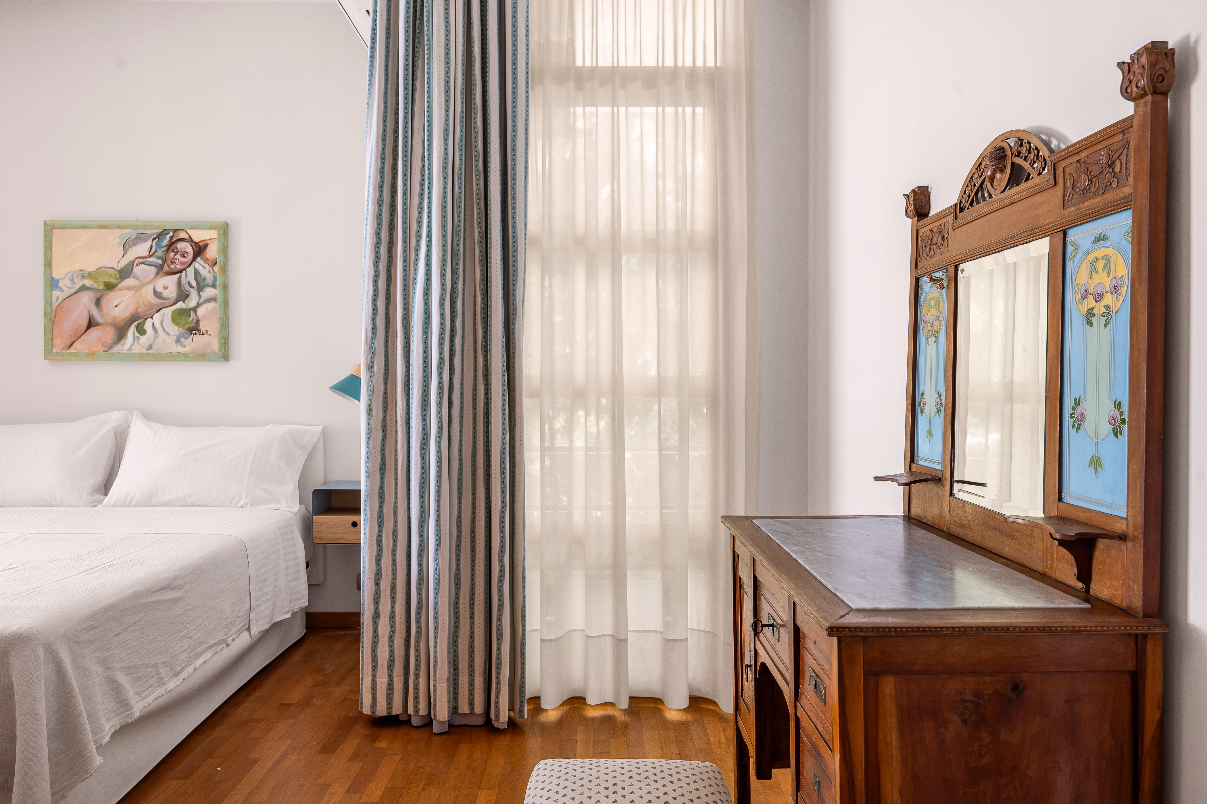 Blue-walled queen bedroom with antique bed and wooden floor